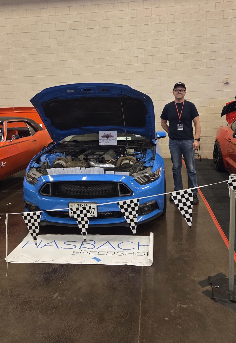 Eduardo Hasbach with his Mustang build at a car show